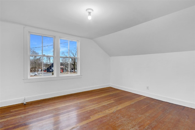 additional living space featuring baseboards, vaulted ceiling, and hardwood / wood-style floors