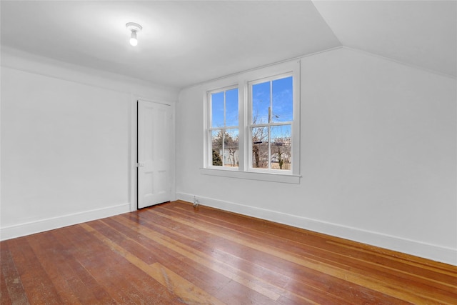 interior space with vaulted ceiling, hardwood / wood-style flooring, and baseboards