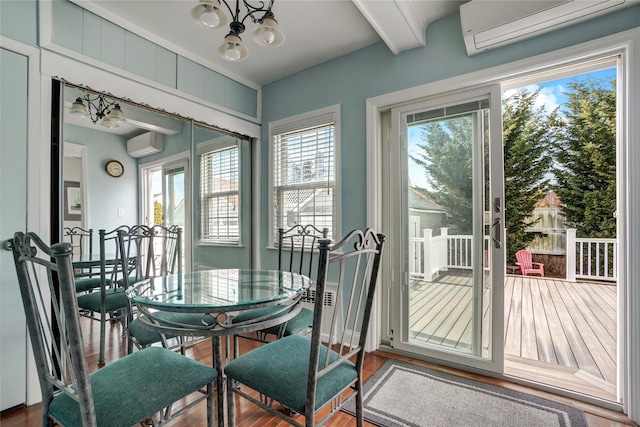 dining area with beam ceiling, a wall mounted air conditioner, and wood finished floors