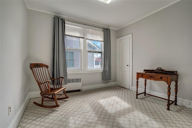 living area featuring crown molding, baseboards, and radiator