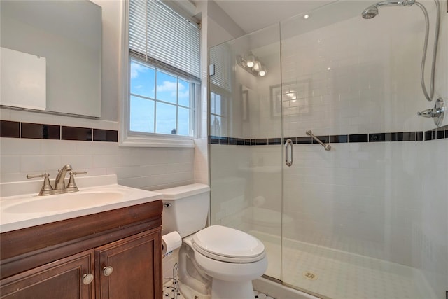 full bath with a stall shower, tasteful backsplash, toilet, vanity, and tile walls