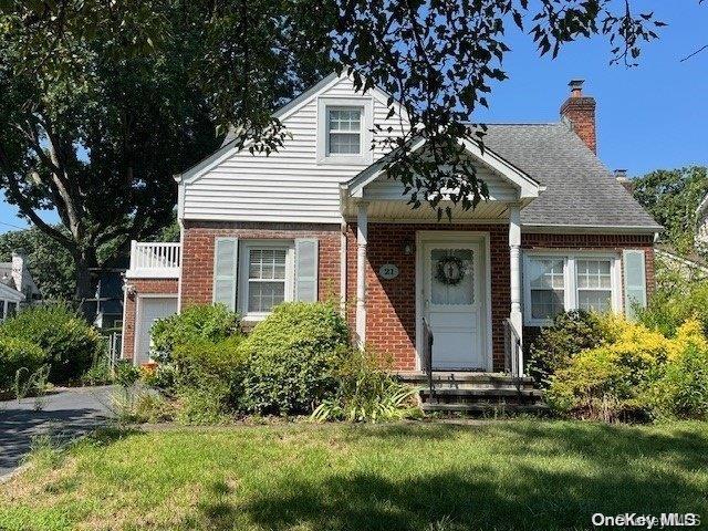 view of front of house with a chimney, a front lawn, and brick siding