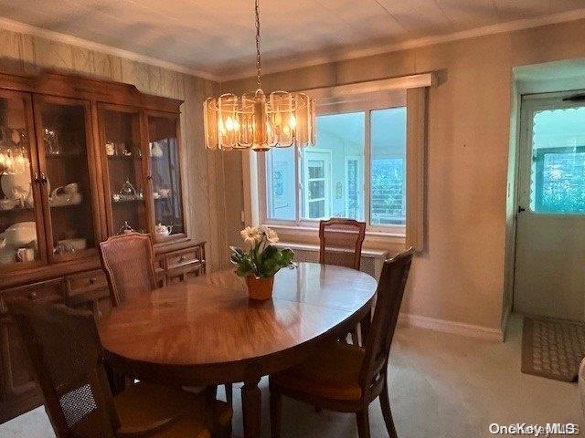 dining room featuring ornamental molding, a chandelier, and baseboards