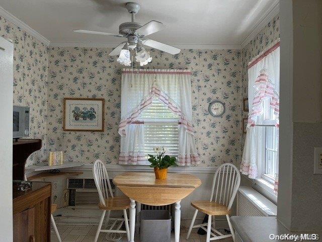 dining space with wallpapered walls and ornamental molding