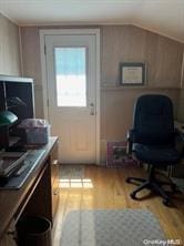 home office with vaulted ceiling and wood finished floors