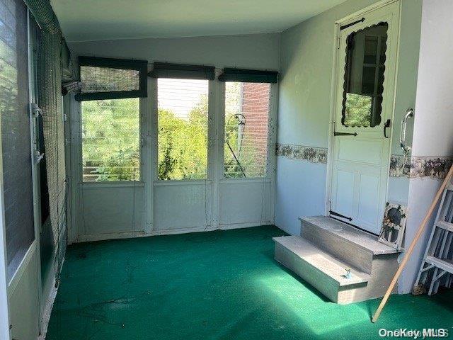 unfurnished sunroom featuring vaulted ceiling