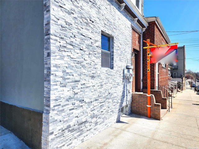 view of property exterior with stone siding and brick siding