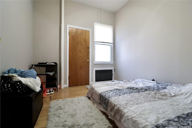 bedroom featuring radiator heating unit and wood finished floors