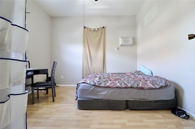 bedroom with baseboards and wood finished floors