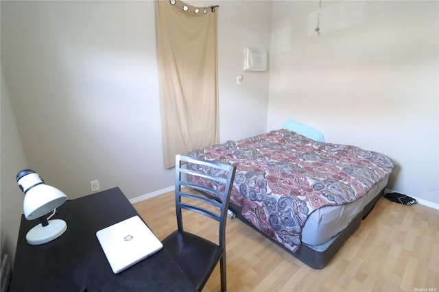 bedroom featuring wood finished floors and baseboards