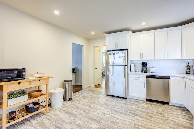 kitchen featuring stainless steel appliances, light countertops, white cabinetry, and decorative backsplash