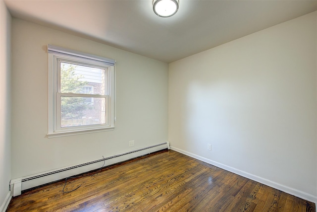 unfurnished room featuring a baseboard heating unit, dark wood-style flooring, and baseboards