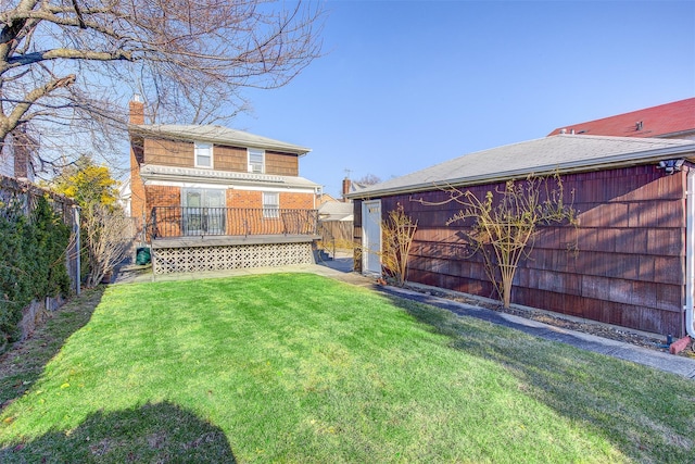 back of house with a fenced backyard, a lawn, a chimney, and brick siding