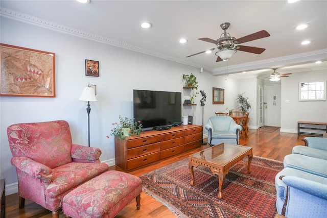 living area featuring crown molding, recessed lighting, ceiling fan, wood finished floors, and baseboards