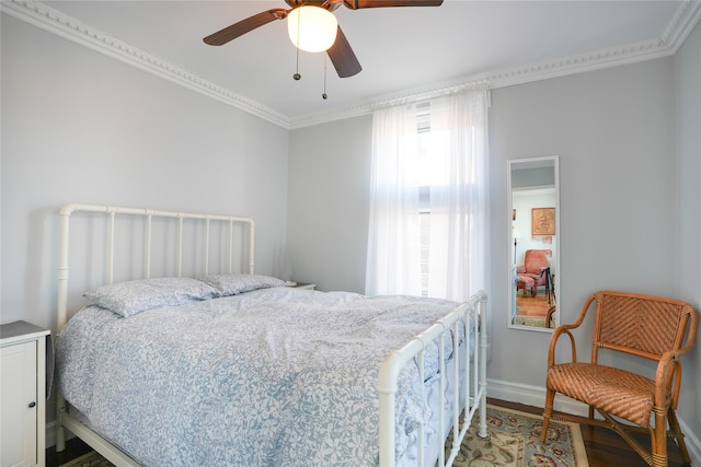 bedroom with a ceiling fan, baseboards, wood finished floors, and ornamental molding