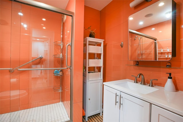 bathroom with a stall shower, decorative backsplash, vanity, and tile walls