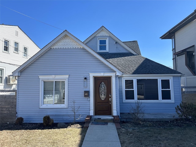 view of front of house with a shingled roof and fence