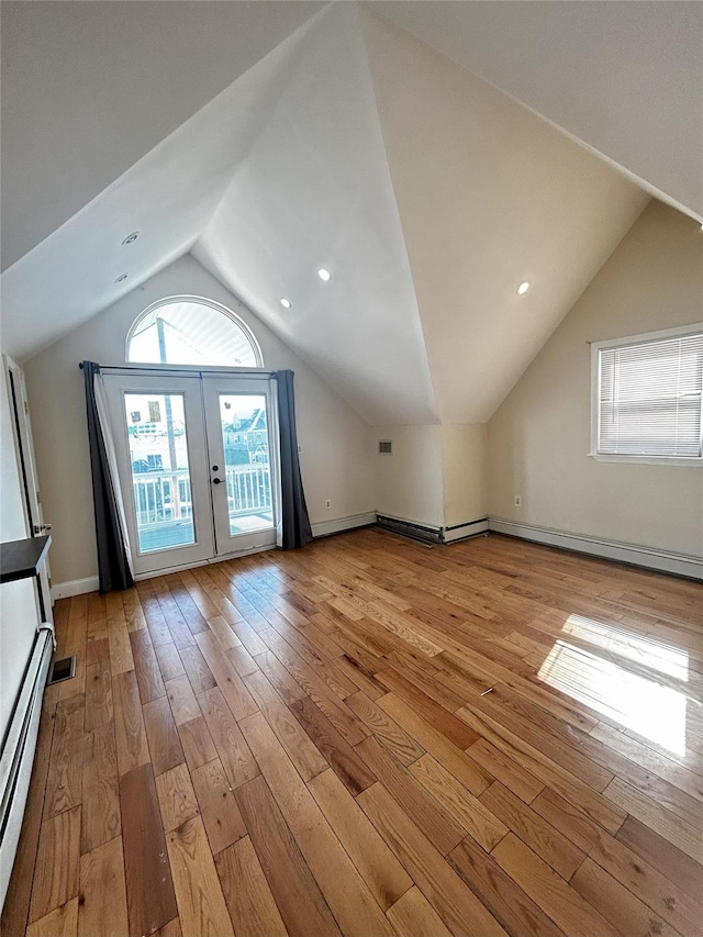 bonus room featuring light wood finished floors, a baseboard heating unit, vaulted ceiling, and french doors