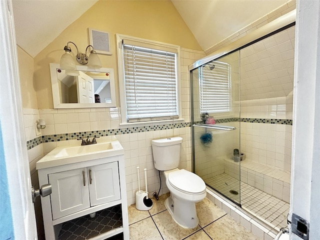 bathroom featuring a stall shower, visible vents, lofted ceiling, toilet, and tile patterned floors