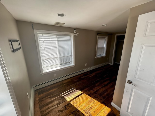 unfurnished bedroom featuring baseboards, visible vents, and wood finished floors