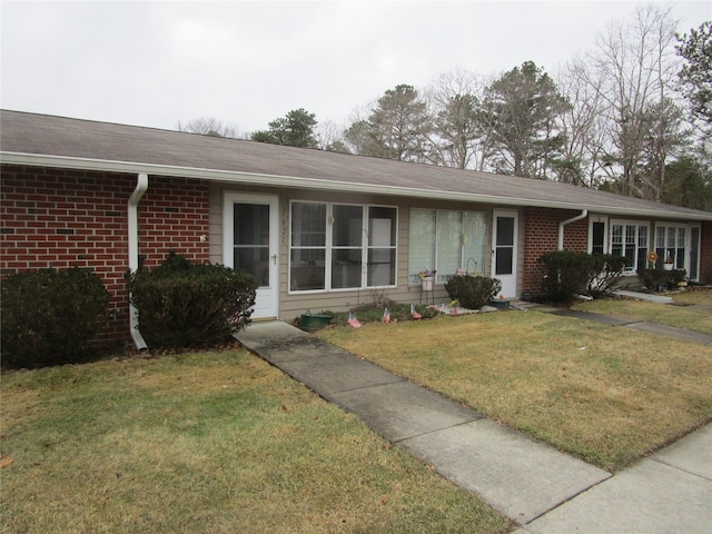 single story home featuring a front yard and brick siding