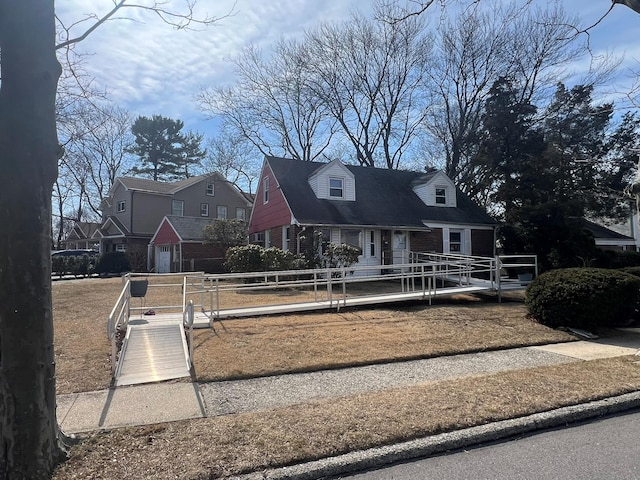 new england style home with a residential view, brick siding, and fence