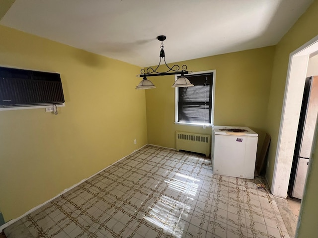 unfurnished dining area with baseboards, an AC wall unit, and radiator