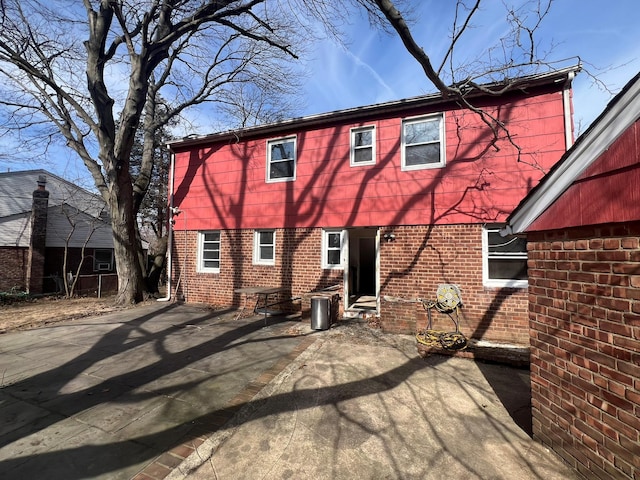 back of house with a patio area and brick siding