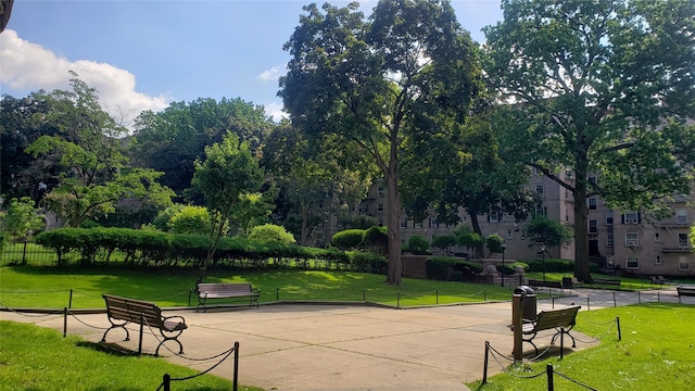 view of property's community with a lawn and fence