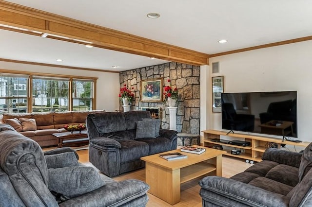 living room featuring recessed lighting, a fireplace, crown molding, and light wood-style flooring