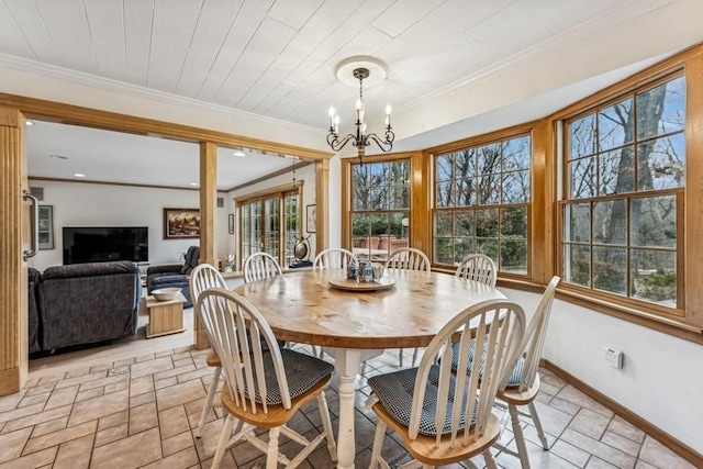 dining area featuring a chandelier, plenty of natural light, baseboards, and crown molding