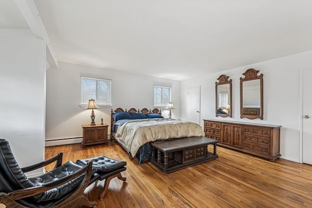 bedroom featuring a baseboard heating unit and wood finished floors