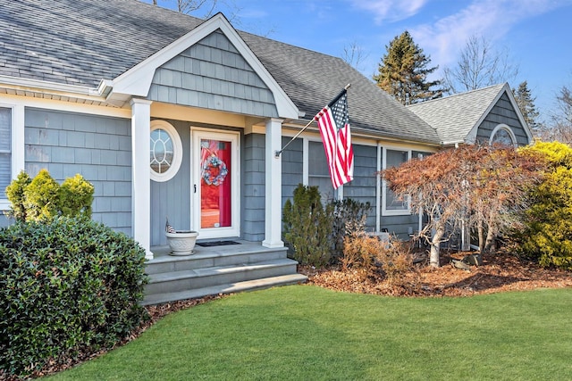 view of front of property with a front lawn and roof with shingles