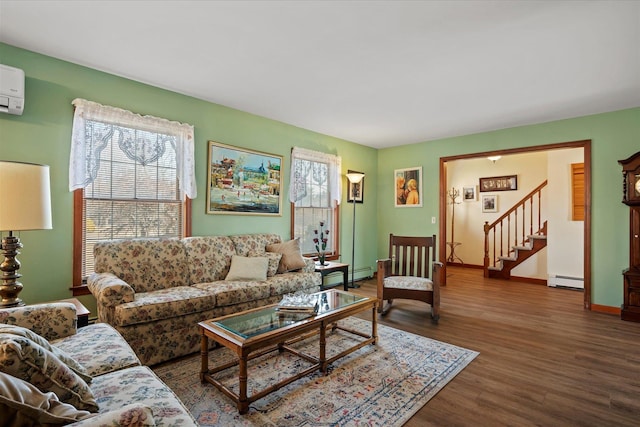 living area with wood finished floors, baseboards, baseboard heating, and stairs