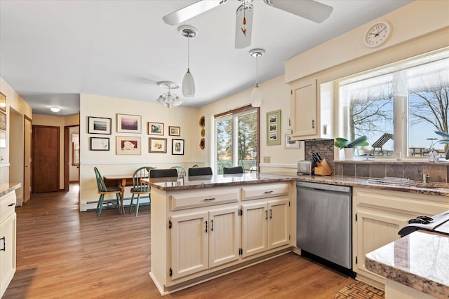 kitchen with a baseboard radiator, a peninsula, hanging light fixtures, dishwasher, and light wood finished floors