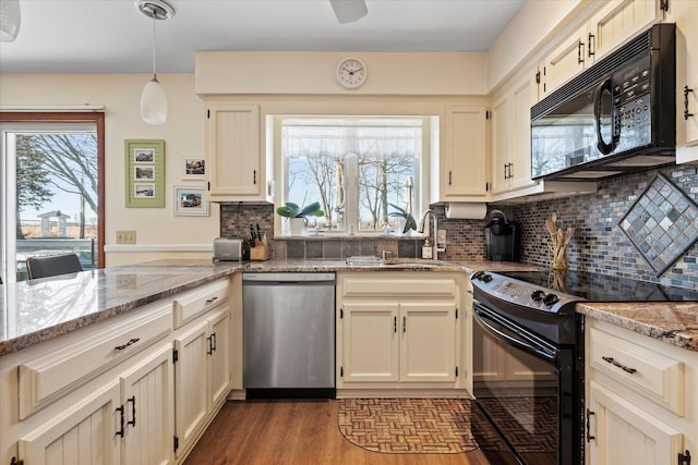 kitchen featuring black appliances, wood finished floors, plenty of natural light, and a sink