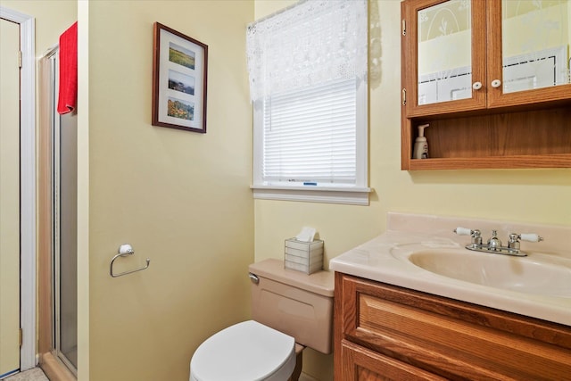 bathroom featuring a shower stall, toilet, and vanity