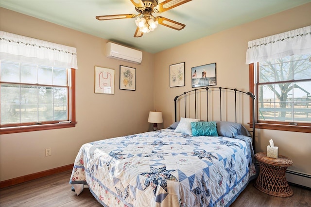 bedroom with a baseboard radiator, wood finished floors, a ceiling fan, baseboards, and an AC wall unit