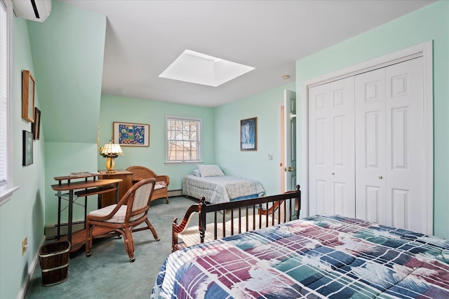 carpeted bedroom with a skylight, a baseboard radiator, a closet, a wall mounted air conditioner, and baseboards