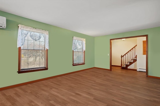 157 Pier Ave, Jamesport, NY 11901 - spare room featuring wood finished floors, a baseboard heating unit, and stairs
