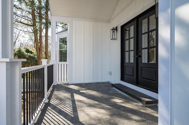 property entrance featuring board and batten siding and french doors