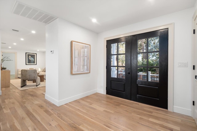 foyer entrance featuring baseboards, visible vents, french doors, light wood-style floors, and recessed lighting