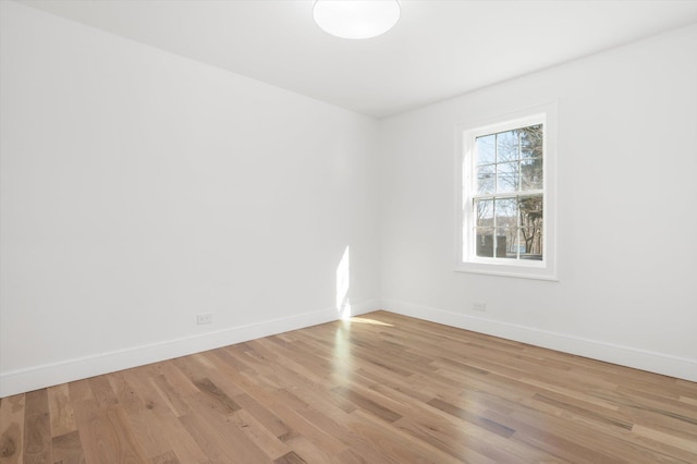 spare room featuring light wood-type flooring and baseboards