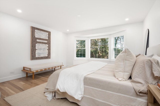 bedroom featuring baseboards, wood finished floors, and recessed lighting