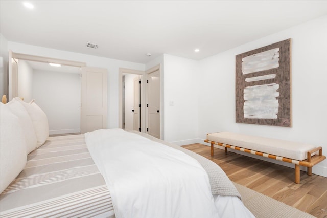 bedroom featuring light wood-type flooring, visible vents, and baseboards