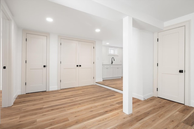 interior space with ensuite bathroom, recessed lighting, baseboards, and light wood-style floors