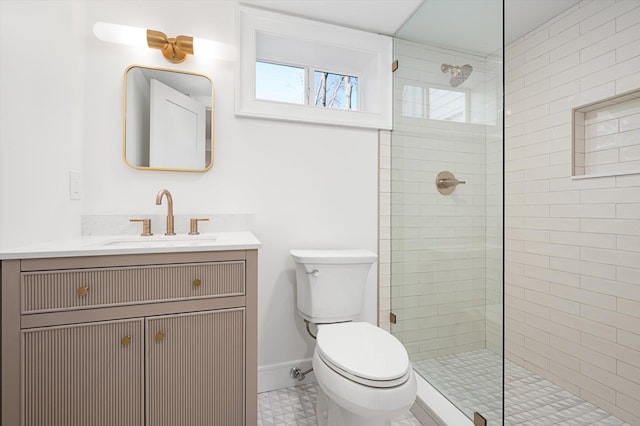 full bathroom featuring toilet, baseboards, a tile shower, and vanity