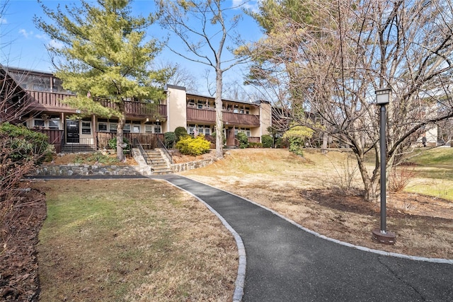 view of home's community with a yard and stairway