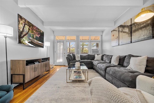 living area with cooling unit, wood finished floors, and beamed ceiling