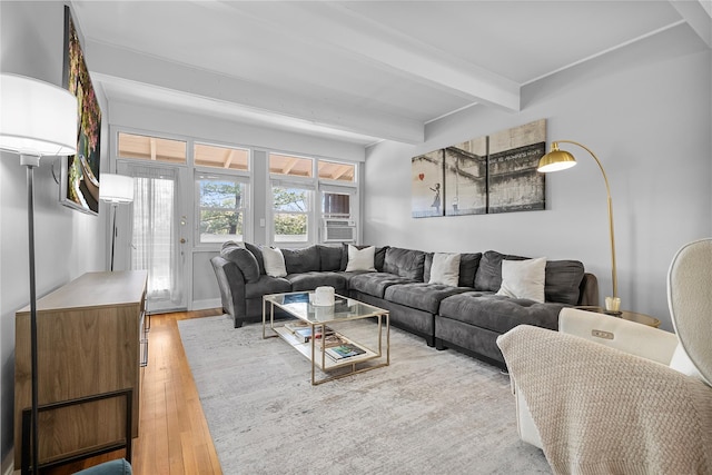 living area featuring beamed ceiling and light wood finished floors